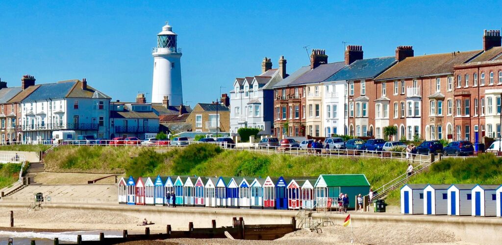 imagen de la playa de suffolk con casetas y un faro mirando al mar del programa junior de inglés y punto